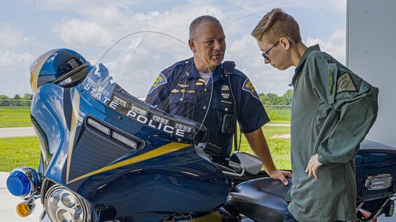 wish kid Johnny looking at State Police motorcycle with Indiana State Police officer