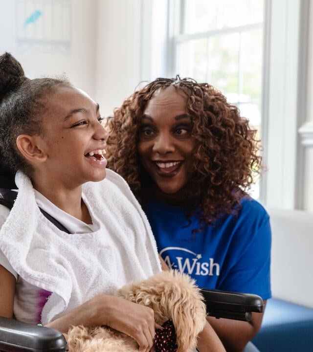 Wish kid Shayna with her maltipoo and volunteer Barbara