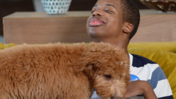 Brendan sits with his doodle puppy, Pluto!