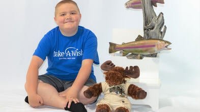 Levi posing with items from his trip to Alaska
