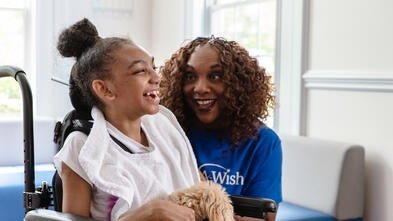Wish kid Shayna with her maltipoo and volunteer Barbara