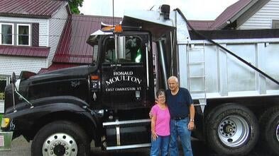 Judy and Ron Moulton stand in front of his commercial truck