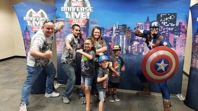 Volunteer Matt with wish kid posing with Captain America