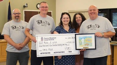Make-A-Wish Regional Manager Maggie O'Brien in the center, with a donation presented by Pocono Mountain West High School faculty members on behalf of the whole school district.