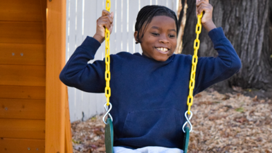 Photo of Davaughn on a swing set