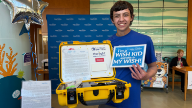Tucker smiling with the donated gaming consoles
