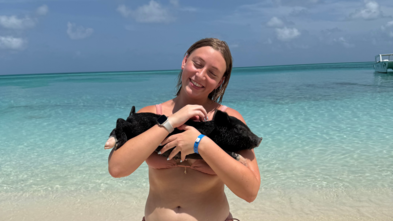 Briana holding a pig on her wish trip to The Bahamas to swim with pigs