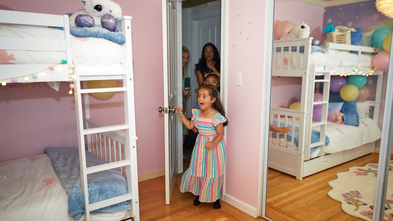 Emma on her wish day, jumping for joy as she sees her new bedroom for the first time. 
