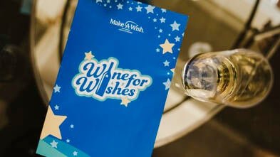 Wine for Wishes program on glass table 