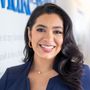 Verónica Quintero, Alumni Storytelling & Content Manager, standing in front of Wish Wall
