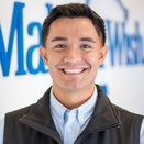 Brandon Beltran, Senior Manager of Philanthropy, in front of Wish Wall