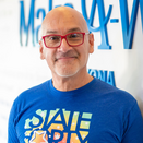 Carlos Inostroza, Senior Wish Manager, standing in front of Wish Wall