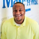 Corey, Wish Manager, standing in front of Wish Wall