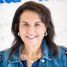 Fran Mallace, President and Chief Executive Officer, smiling in front of Wish Wall