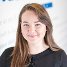 Haley Schulze, Donor Care Associate, in front of Wish Wall